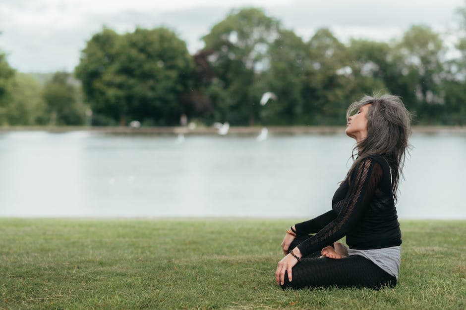 Mujer meditando en un parque.