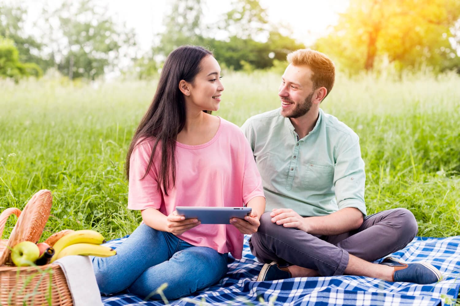 Pareja feliz conversando al aire libre, trabajando juntos en superar los celos y fortalecer su relación.