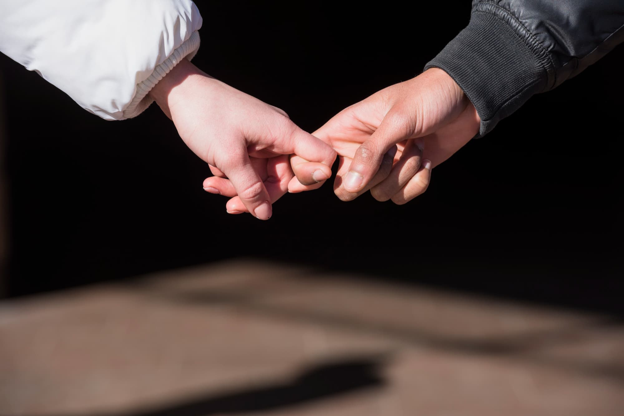 Manos entrelazadas representando la importancia de la confianza en una relación de pareja exitosa y duradera.