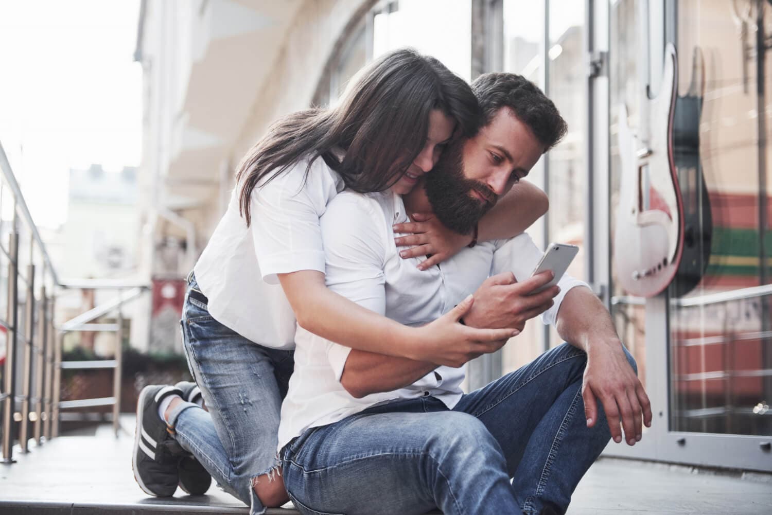 Pareja compartiendo un momento íntimo junto a una pantalla de redes sociales