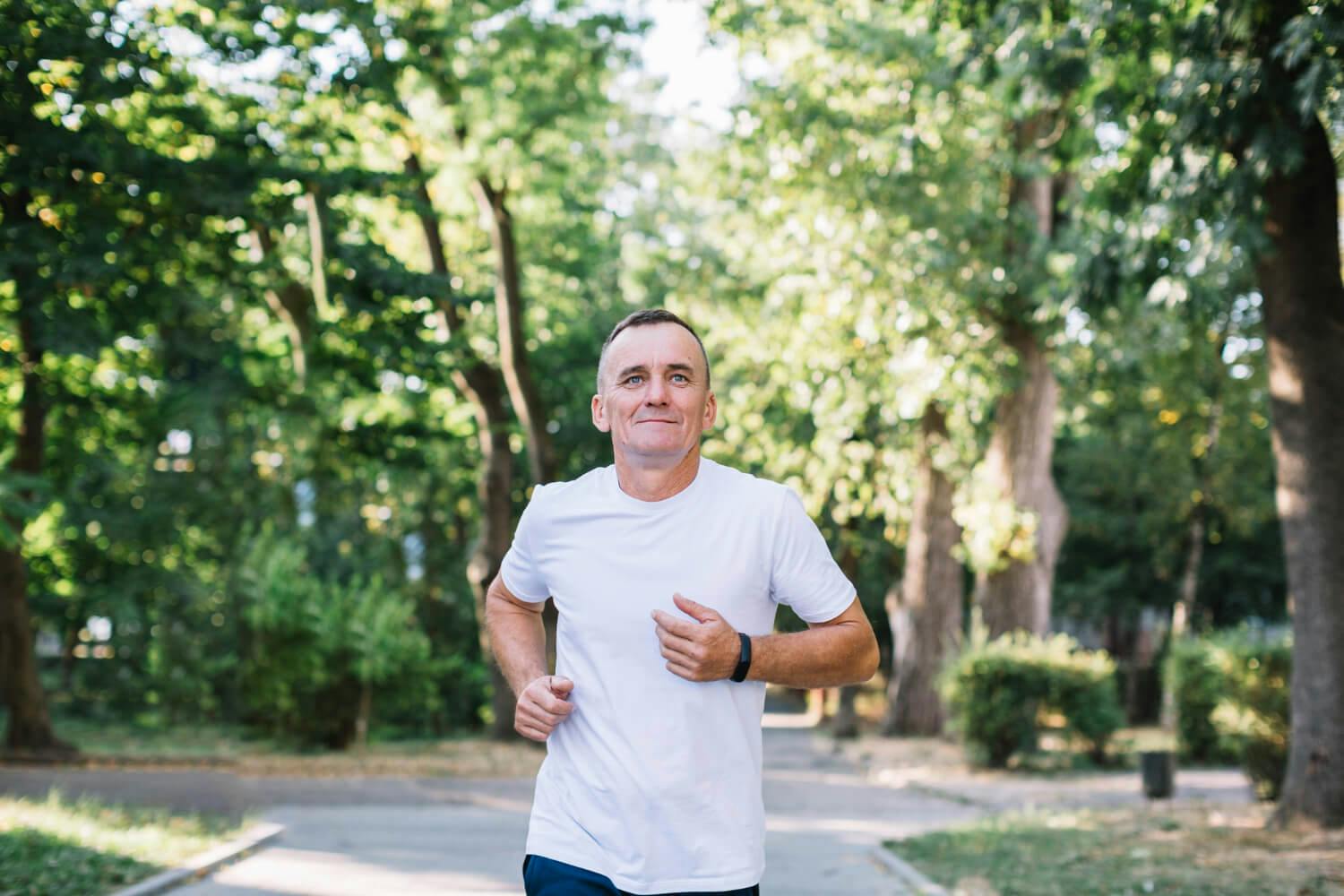 Hombre corriendo al aire libre en un parque como parte de su rutina diaria de ejercicio para combatir el insomnio y la ansiedad.