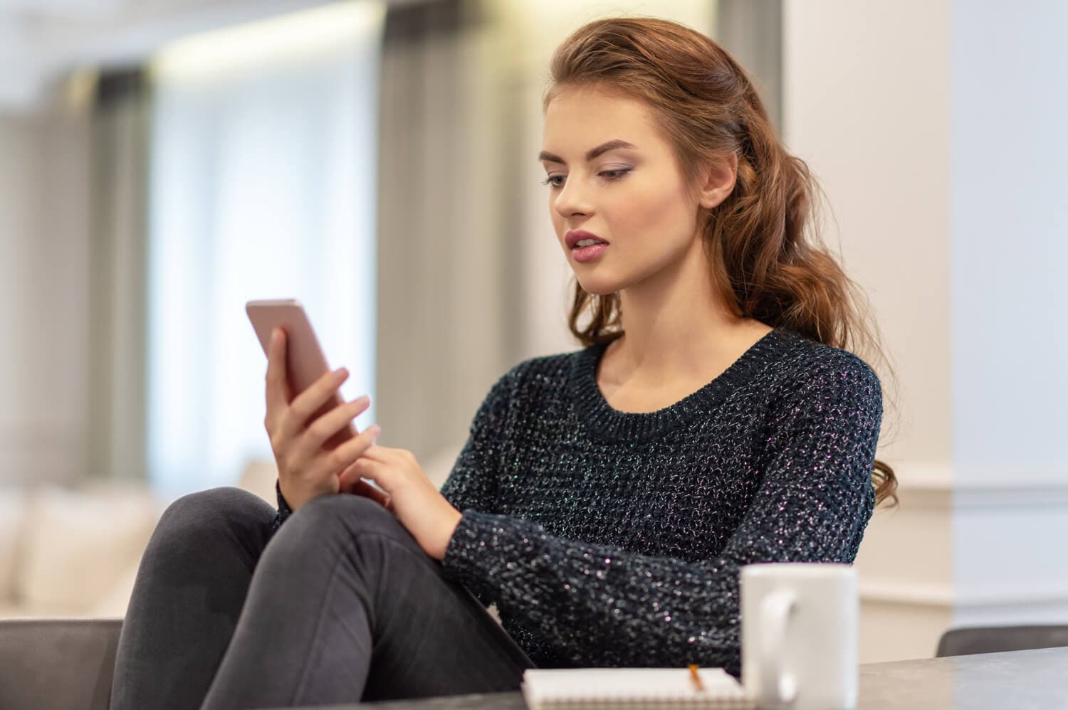Mujer consultando su teléfono constantemente.