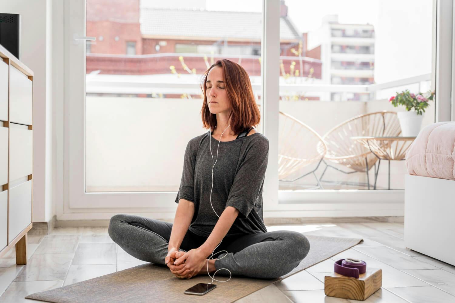 Una mujer practicando técnicas de relajación en un ambiente tranquilo para manejar la ansiedad y mejorar su autocontrol emocional.
