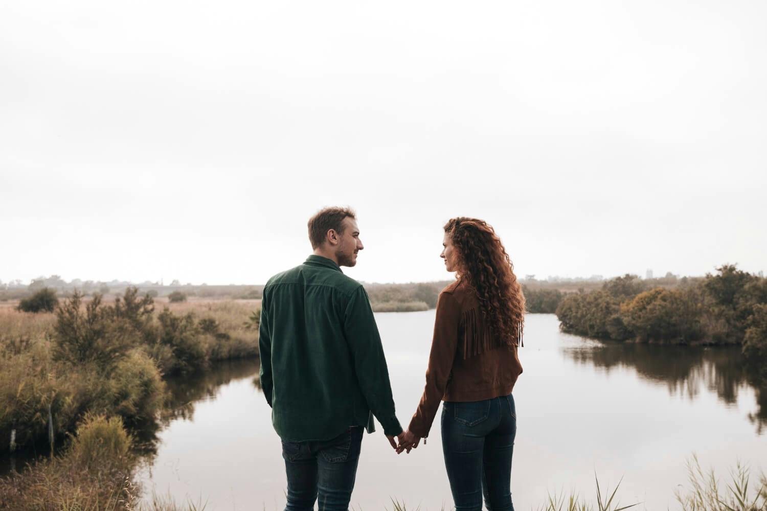 Una pareja tomados de la mano mirando el horizonte, simbolizando la búsqueda de superación de la dependencia emocional en su relación.