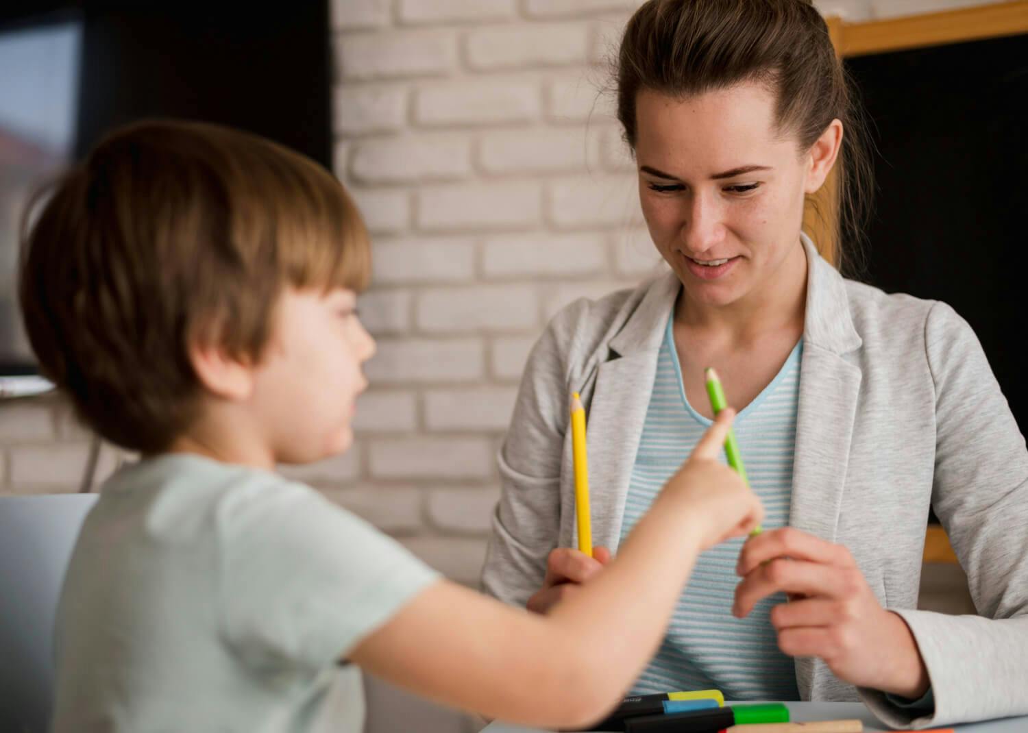 Terapeuta trabajando con un niño en una sesión de terapia, un enfoque común para tratar el trastorno por déficit de atención e hiperactividad (TDAH) y el autismo.